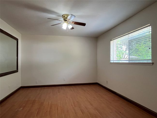Unfurnished room with wood finished floors, a ceiling fan, and baseboards | Image 13