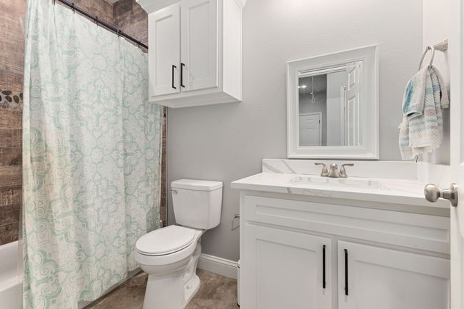 Full bathroom featuring shower / tub combo with curtain, vanity, and toilet | Image 20