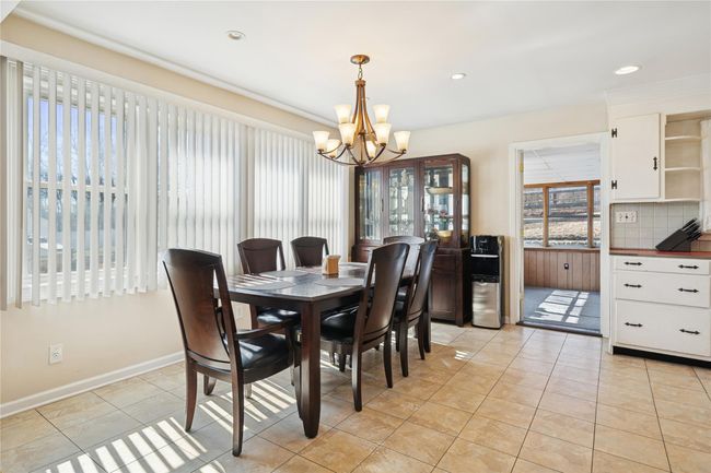Dining area with light tile patterned floors, recessed lighting, baseboards, and a chandelier | Image 16