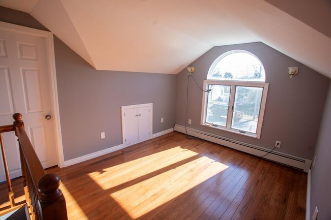 Additional living space with baseboard heating, wood-type flooring, and lofted ceiling | Image 18