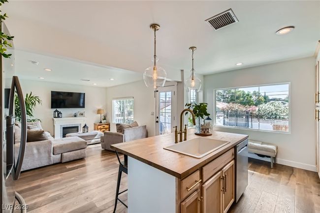 Kitchen featuring a sink, stainless steel dishwasher, butcher block counters, light wood-type flooring. | Image 14