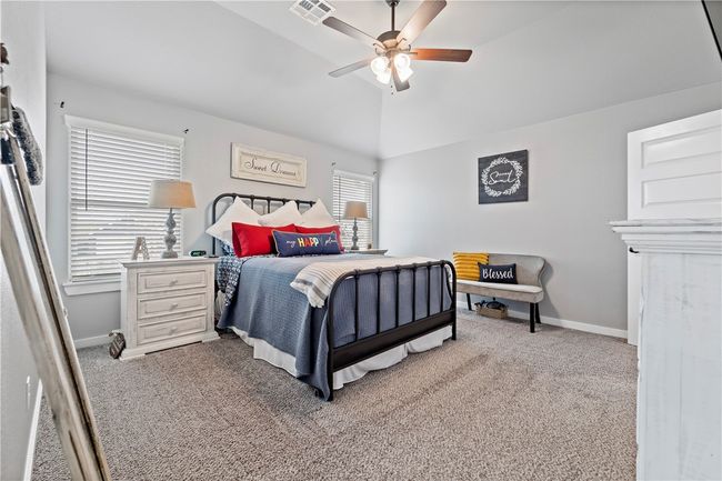 Carpeted bedroom with baseboards, lofted ceiling, visible vents, and a ceiling fan | Image 21