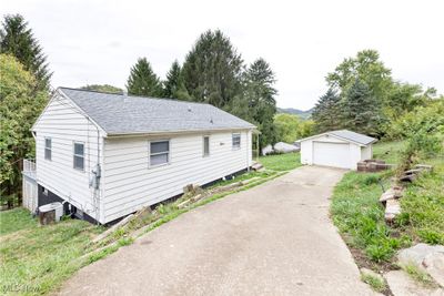 View of front of house featuring an outdoor structure, a garage, and central air condition unit | Image 2