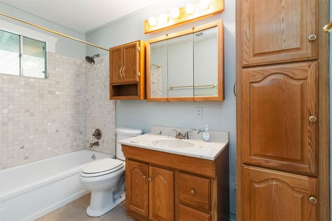 Bathroom with tile patterned floors, toilet, vanity, and shower / bathtub combination | Image 19