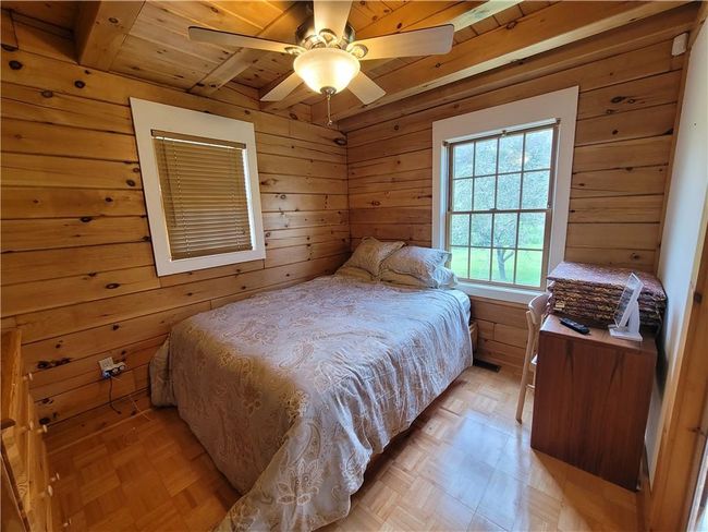 Bedroom featuring wood ceiling, ceiling fan, and light parquet flooring | Image 14