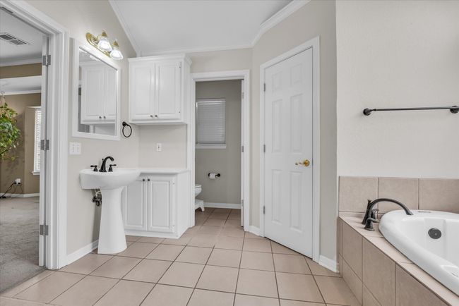 Bathroom featuring ornamental molding, a bath, toilet, baseboards, and tile patterned floors | Image 18