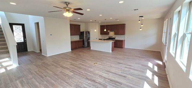 Kitchen and living area with open floor plan, appliances with stainless steel finishes, healthy amount of natural light, light countertops, and recessed lighting | Image 7