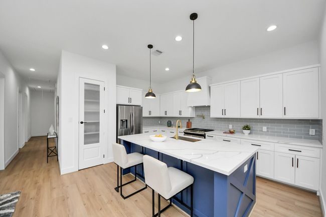 The focal point is a sleek island thatnot only provides additional counterspace but also serves as a casualgathering spot. | Image 8