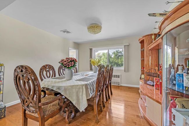 Dining space featuring light wood-style flooring and radiator | Image 4