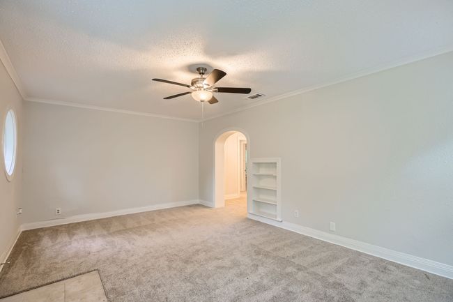Spare room with ceiling fan, visible vents, carpet, a textured ceiling, and arched walkways | Image 8