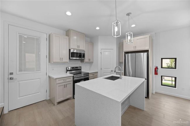 Kitchen featuring appliances with stainless steel finishes, light wood-style floors, decorative light fixtures, backsplash, and recessed lighting | Image 9