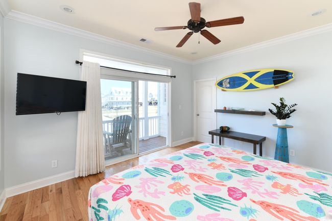 Bedroom featuring light wood finished floors, access to outside, ornamental molding, and baseboards | Image 9