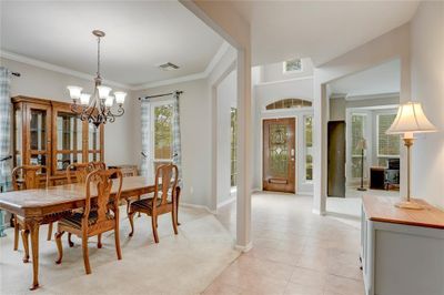 BRIGHT AND WELCOMING ENTRY WITH SOARING CEILINGS, AN INVITING FORMAL DINING ROOM, AND STYLISH ARCHITECTURAL DETAILS. | Image 3