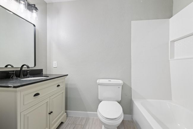 Bathroom with toilet, wood finished floors, baseboards, and vanity | Image 16