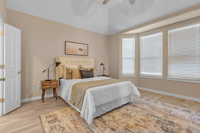 Bedroom featuring light wood-style floors, lofted ceiling, and ceiling fan | Image 18