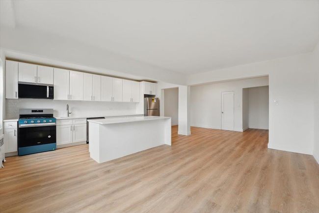 Kitchen with light countertops, white cabinets, and stainless steel appliances | Image 9