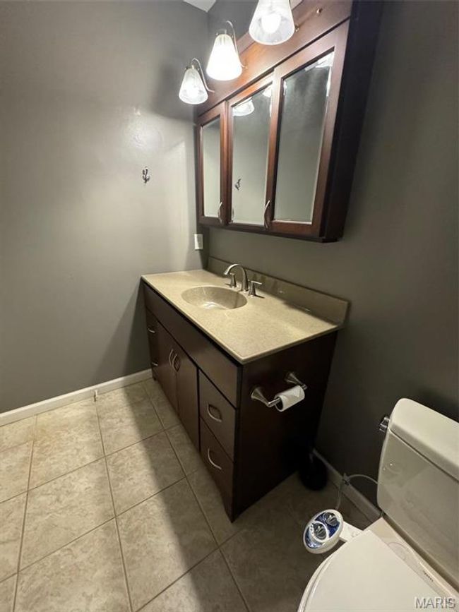 primary bathroom with toilet, vanity, and tile patterned floors | Image 25