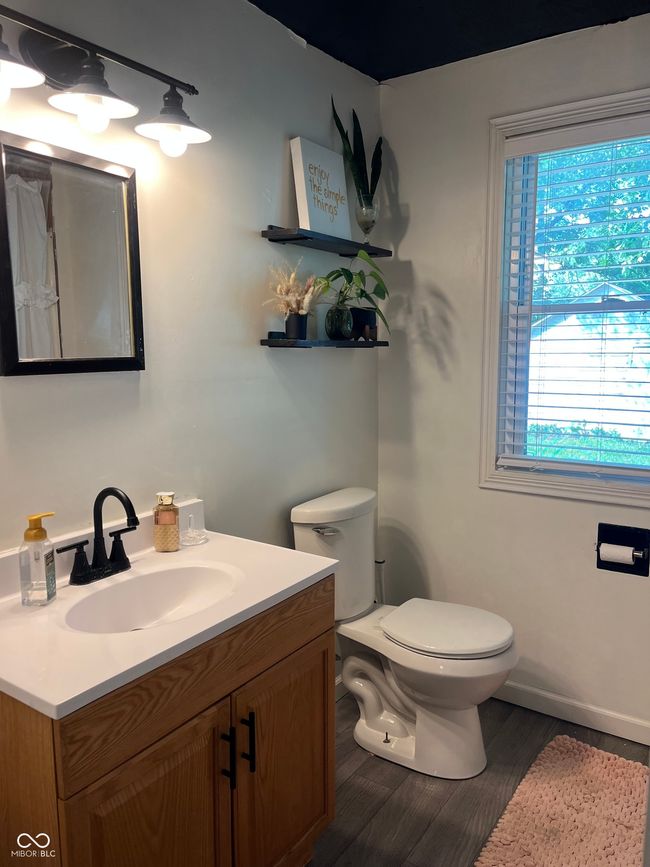 bathroom featuring toilet, vanity, and wood finished floors | Image 9