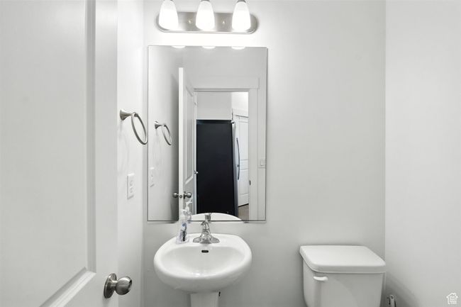 Bathroom with toilet and a sink | Image 7