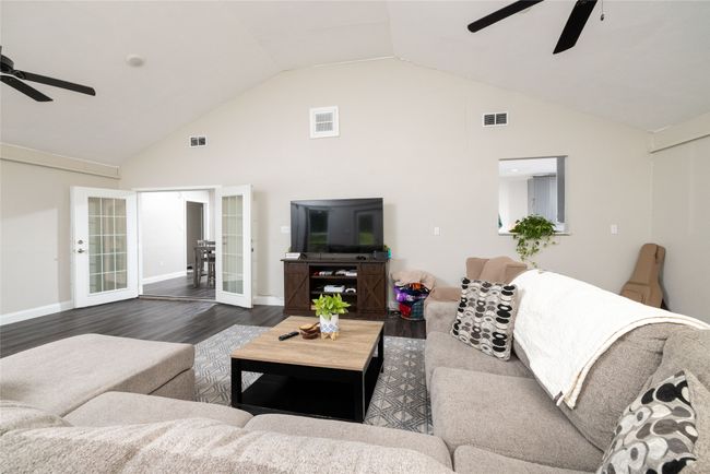 Living area with french doors, ceiling fan, visible vents, and dark wood-style flooring | Image 22