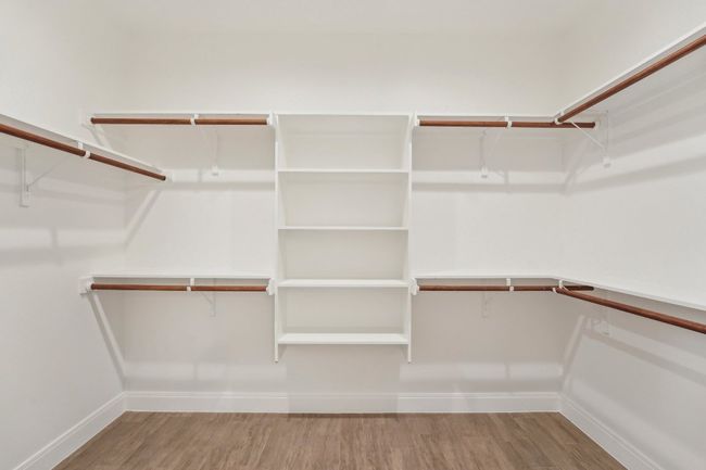 Spacious Primary closet featuring wood style floors | Image 25