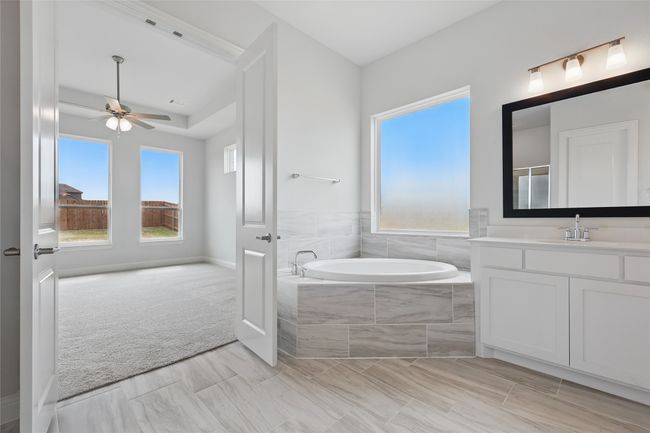 Full bathroom featuring a ceiling fan, vanity, visible vents, and a bath | Image 18