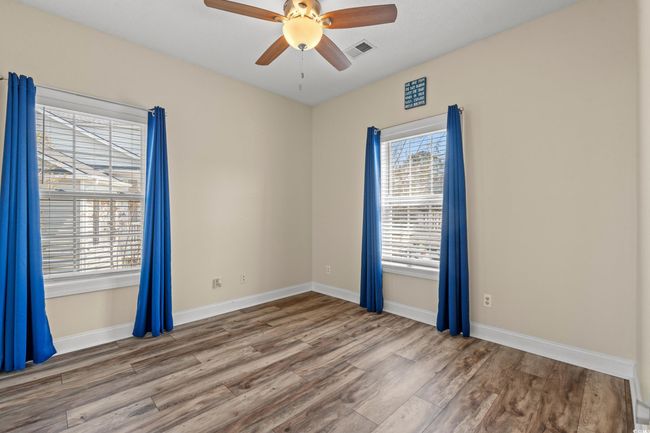 Unfurnished room with a ceiling fan, visible vents, baseboards, and wood finished floors | Image 16