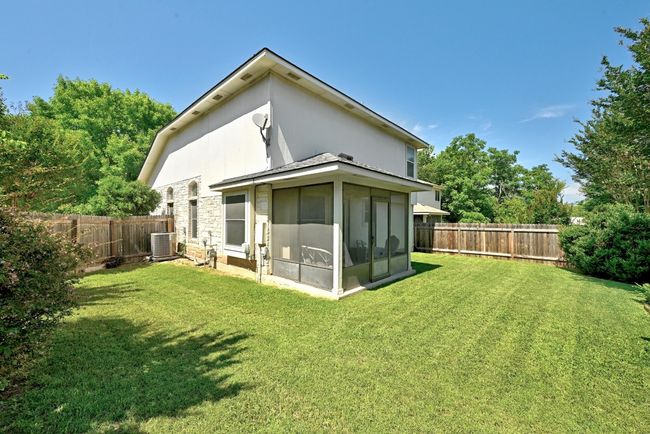 Rear view of property featuring a sunroom, cooling unit, and stone siding | Image 29