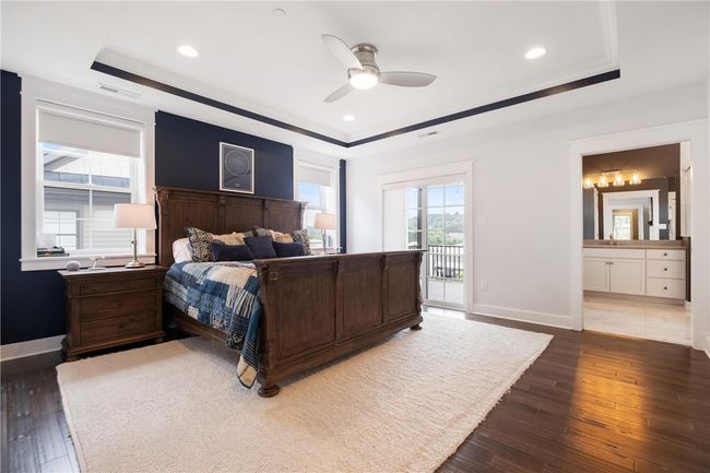 Spacious Owner's Suite on second floor has hardwood floor, 2 walk-in closets, ceiling fan/light, private luxury bath and sliding door to private covered deck. | Image 20