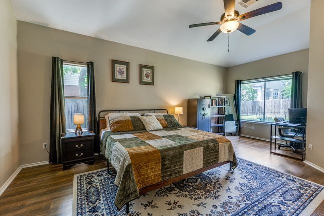 Bedroom featuring multiple windows, wood finished floors, and baseboards | Image 11