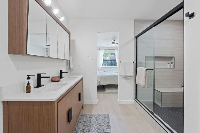 Ensuite bathroom with double vanity, wood finished floors, a shower stall, and a ceiling fan | Image 21