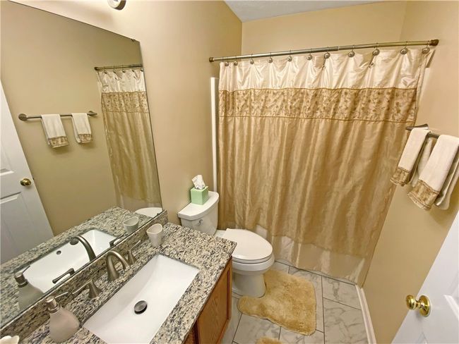 Main bath features a newer floor and a vanity sink with a granite countertop. | Image 20