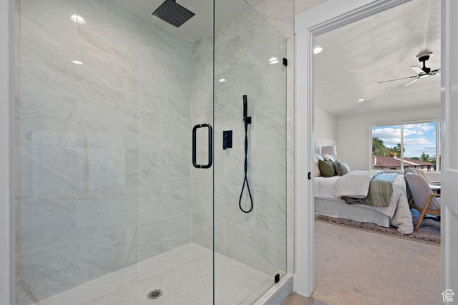 Ensuite primary bathroom featuring a stall shower, a ceiling fan, and lofted ceiling | Image 21