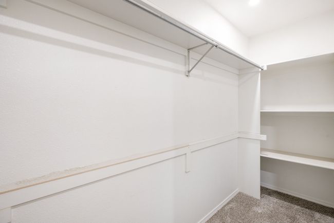 Walk in closet featuring light colored carpet | Image 18