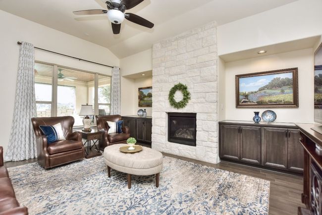 Living area with a fireplace, wood finished floors, a ceiling fan, and vaulted ceiling | Image 10