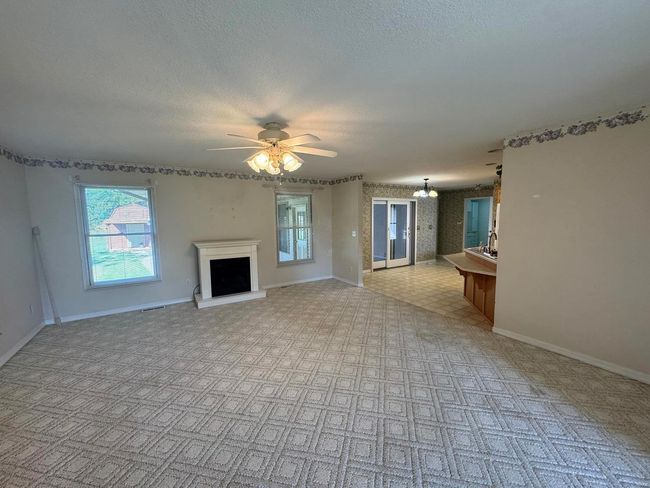 Unfurnished living room with ceiling fan and a textured ceiling | Image 10