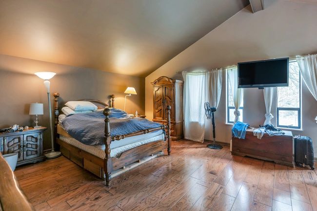 Bedroom with hardwood / wood-style flooring and vaulted ceiling | Image 23