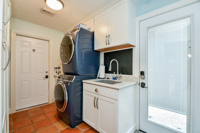 This is the spacious utility room, with sink, storage and handy patio door. | Image 42