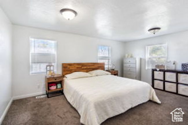Bedroom with carpet, baseboards, and multiple windows | Image 13