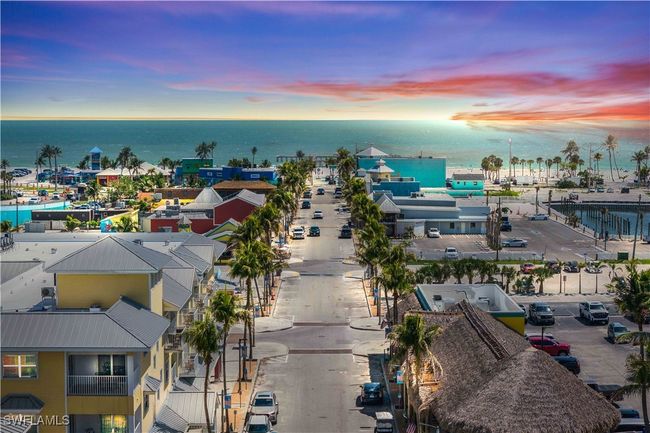 From above, the streets of Fort Myers Beach unfold in a charming grid, lined with tropical trees and colorful homes, all leading directly to the inviting sandy shoreline and shimmering Gulf beyond. | Image 34