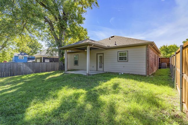 Rear view of property featuring a patio area, brick siding, a fenced backyard, a shingled roof, and a lawn | Image 24