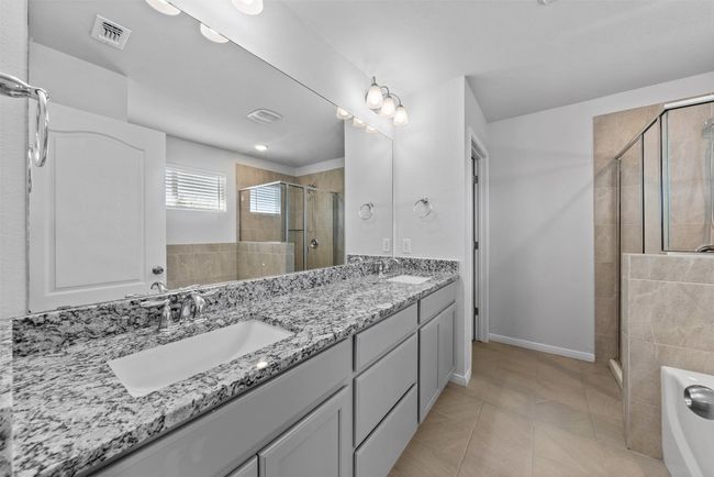 Full bathroom featuring a stall shower, double vanity, a tub to relax in, and tile patterned floors | Image 26
