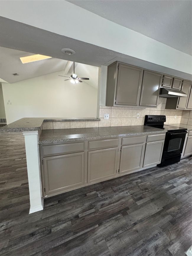 Kitchen featuring range, dark wood-style flooring, gray cabinetry, and ceiling fan | Image 9