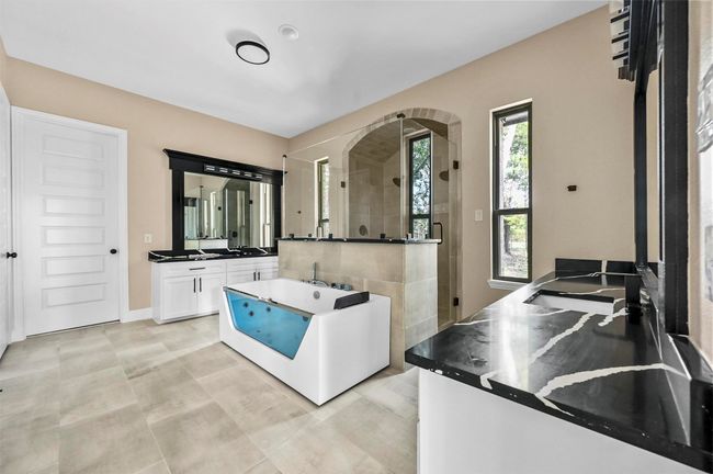 Kitchen with dark countertops, white cabinetry, and baseboards | Image 35