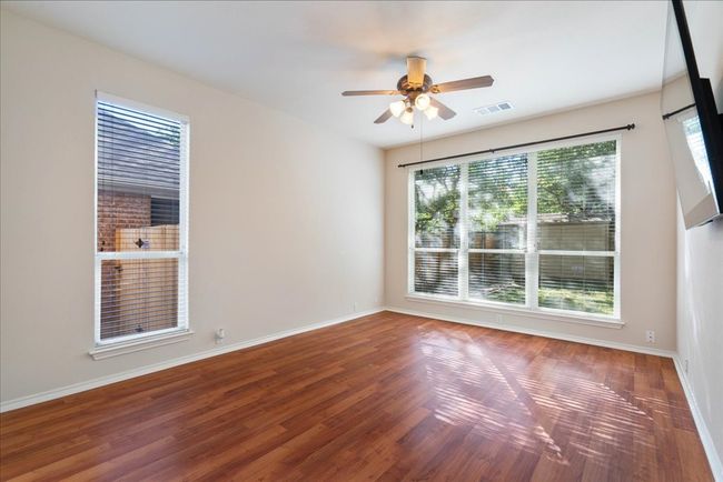 Unfurnished room featuring baseboards, wood finished floors, visible vents, and ceiling fan | Image 9