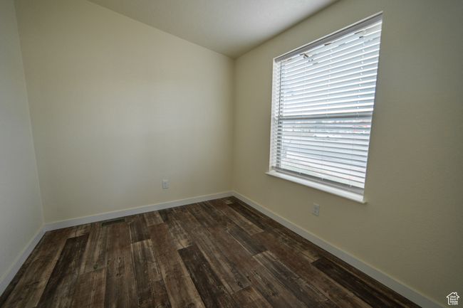 Empty room featuring a wealth of natural light, dark wood-style flooring, visible vents, and baseboards | Image 17
