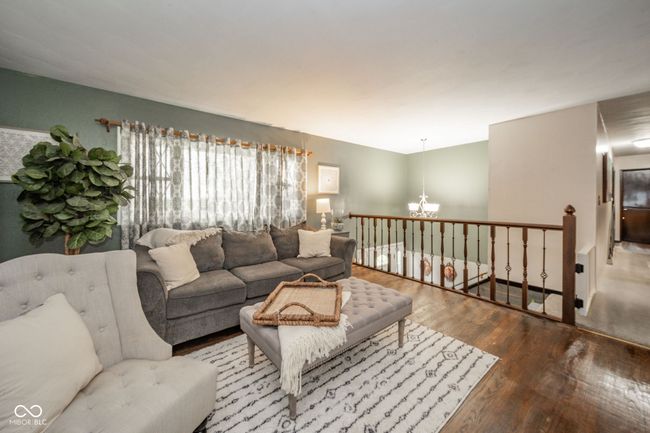 living area featuring an inviting chandelier and wood finished floors | Image 34