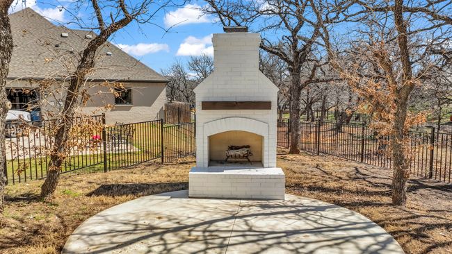 View of patio / terrace with fence and an outdoor brick fireplace | Image 36