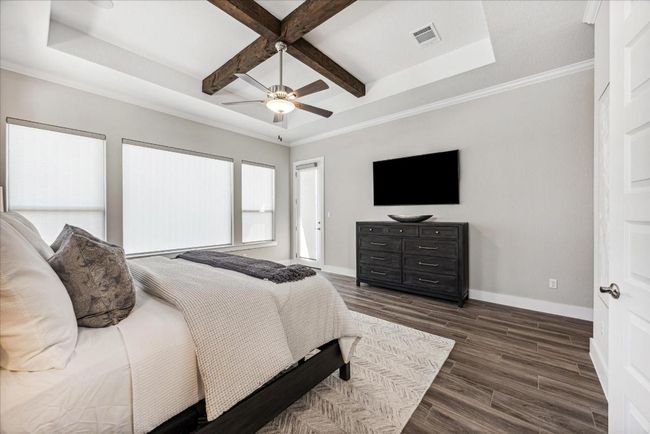 A pop-up ceiling with exposed wood beams adds architectural flair and character to the primary bedroom. Private access the to the covered patio allows you to sneak out and enjoy the early morning sunrise. | Image 18