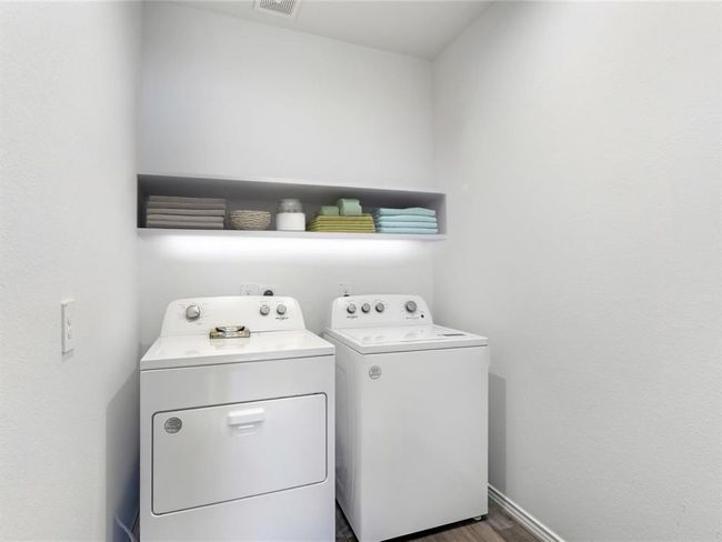 AI Enhanced | Dedicated laundry room with full-size washer and dryer, upper shelf storage, and easy access. | Image 6
